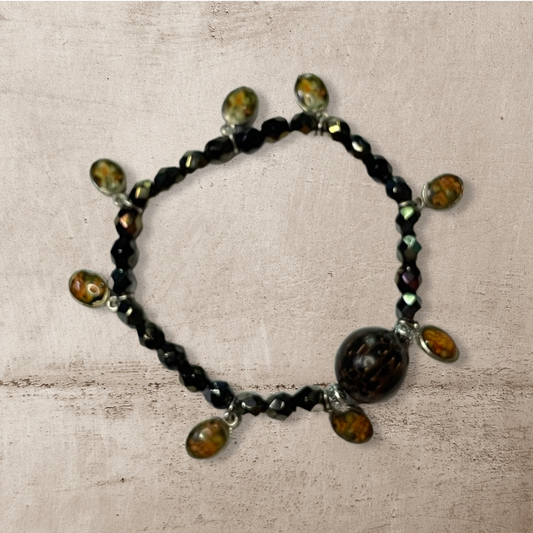 Saintly. Stretch bracelet made with wood, czech glass beads and accent charms.